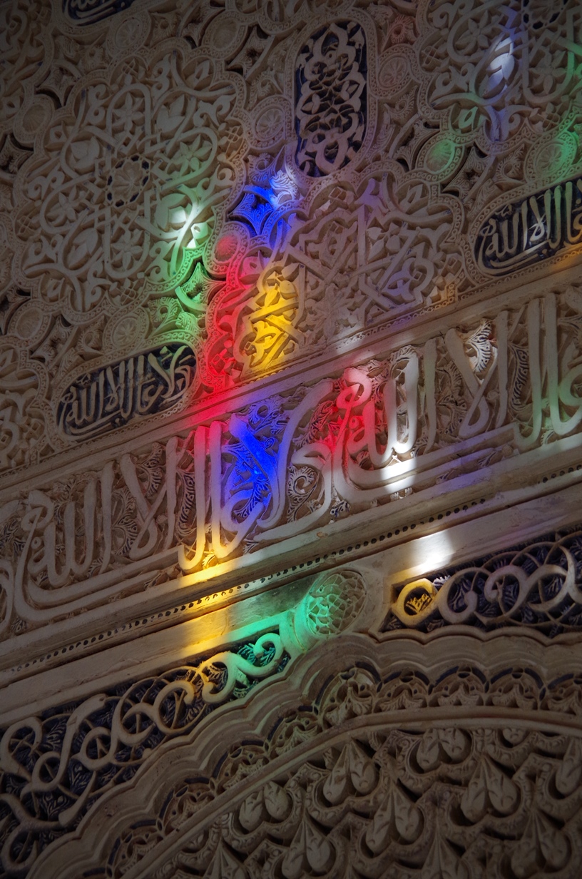 Bunte Lichter spiegeln sich an der Wand einer Moschee